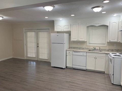 A kitchen with white appliances and cabinets.