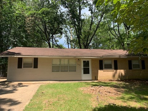a white house with a yard and trees