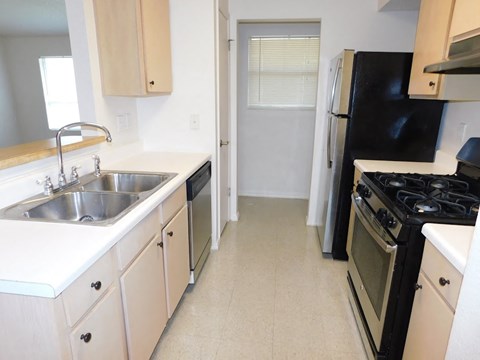 a kitchen with a sink and a stove and a refrigerator