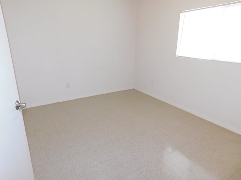 an empty room with white walls and a window