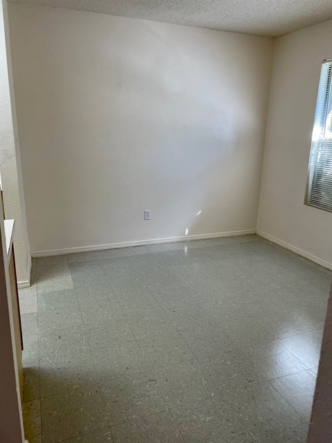 an empty room with white walls and a tiled floor
