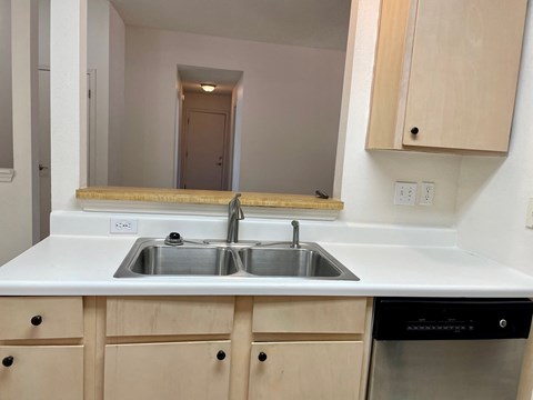 an empty kitchen with a sink and a mirror