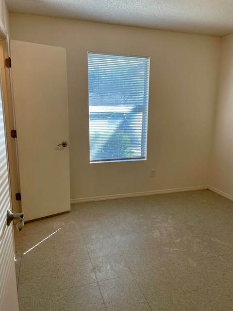 an empty room with a window and a door