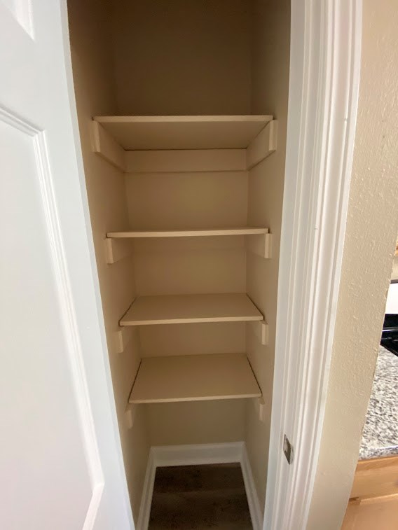 Empty white shelves in a white cabinet.
