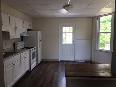 A kitchen with white cabinets and appliances.