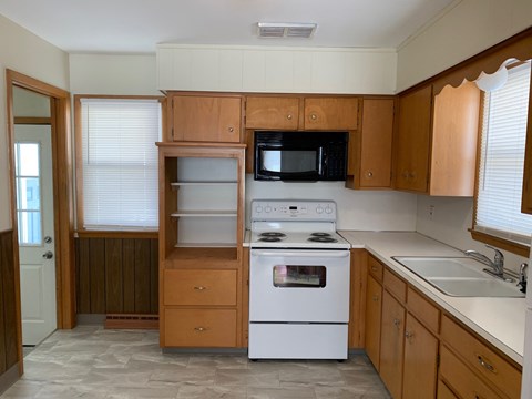 A kitchen with wooden cabinets and a white oven.