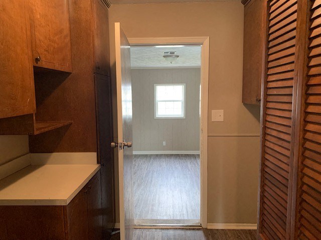 an empty kitchen with a door open to a room