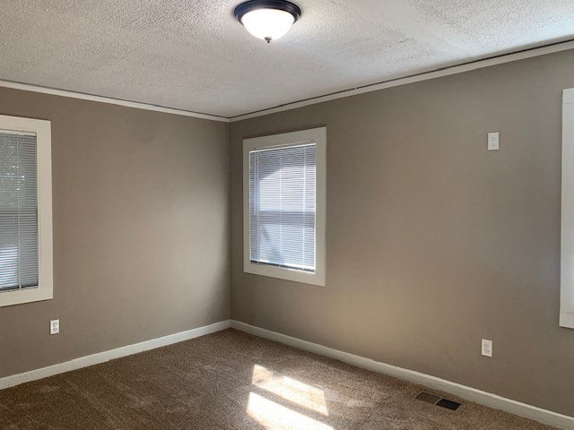 an empty room with a window and a ceiling light