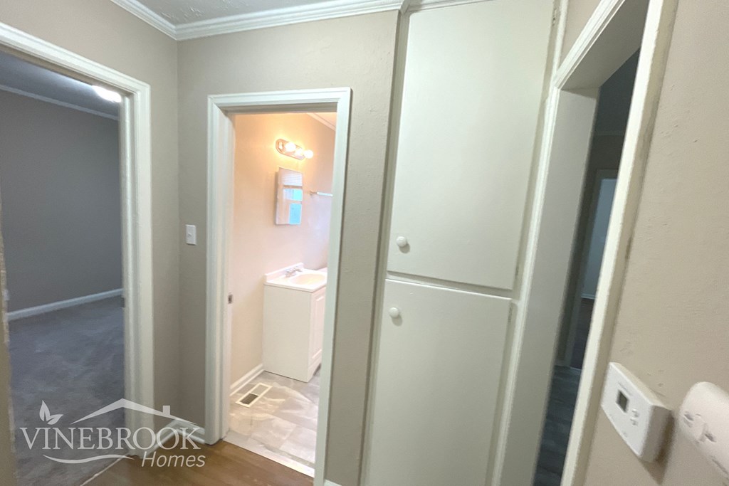 a bathroom with a closet and a toilet and a mirror