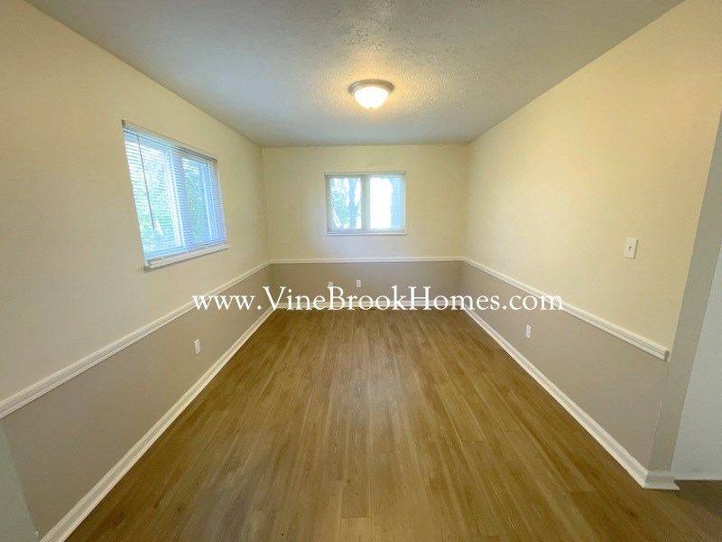 an empty living room with hardwood floors and a window