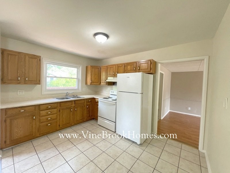 a kitchen with white appliances and wooden cabinets