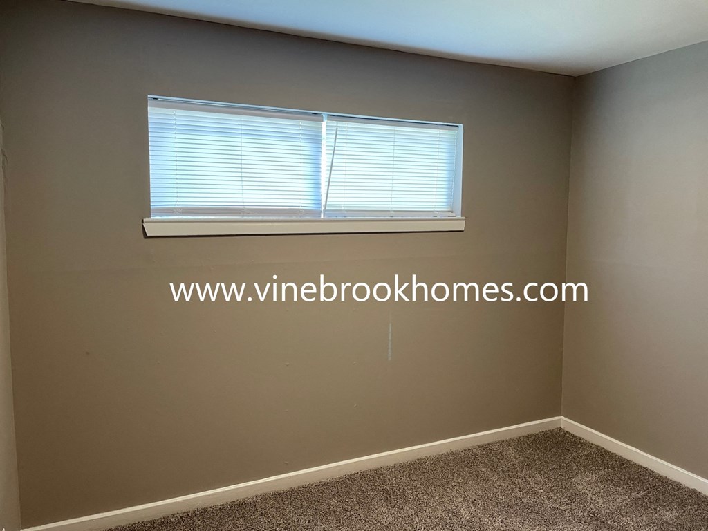 a small room with a window and a carpet