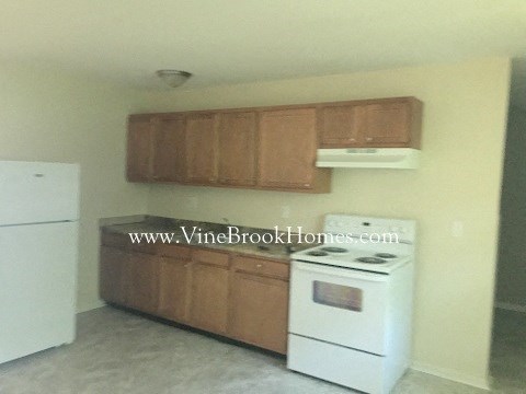 A kitchen with a white stove and white refrigerator.