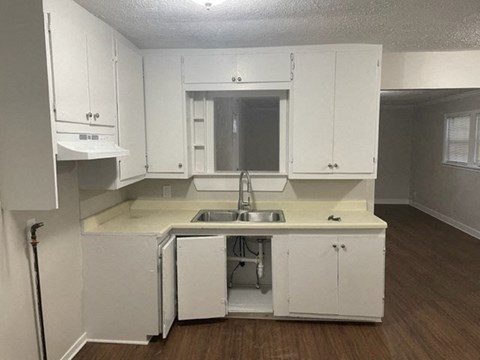 A kitchen with white cabinets and a sink.