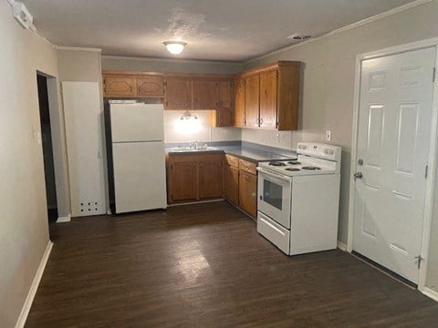 a kitchen with a white stove and a refrigerator