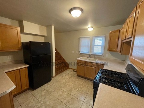 A kitchen with black appliances and wooden cabinets.