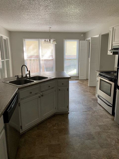 A kitchen with a sink and a stove.