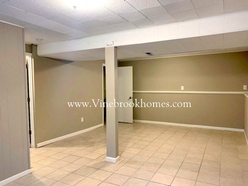 an empty room with two pillars and a tiled floor