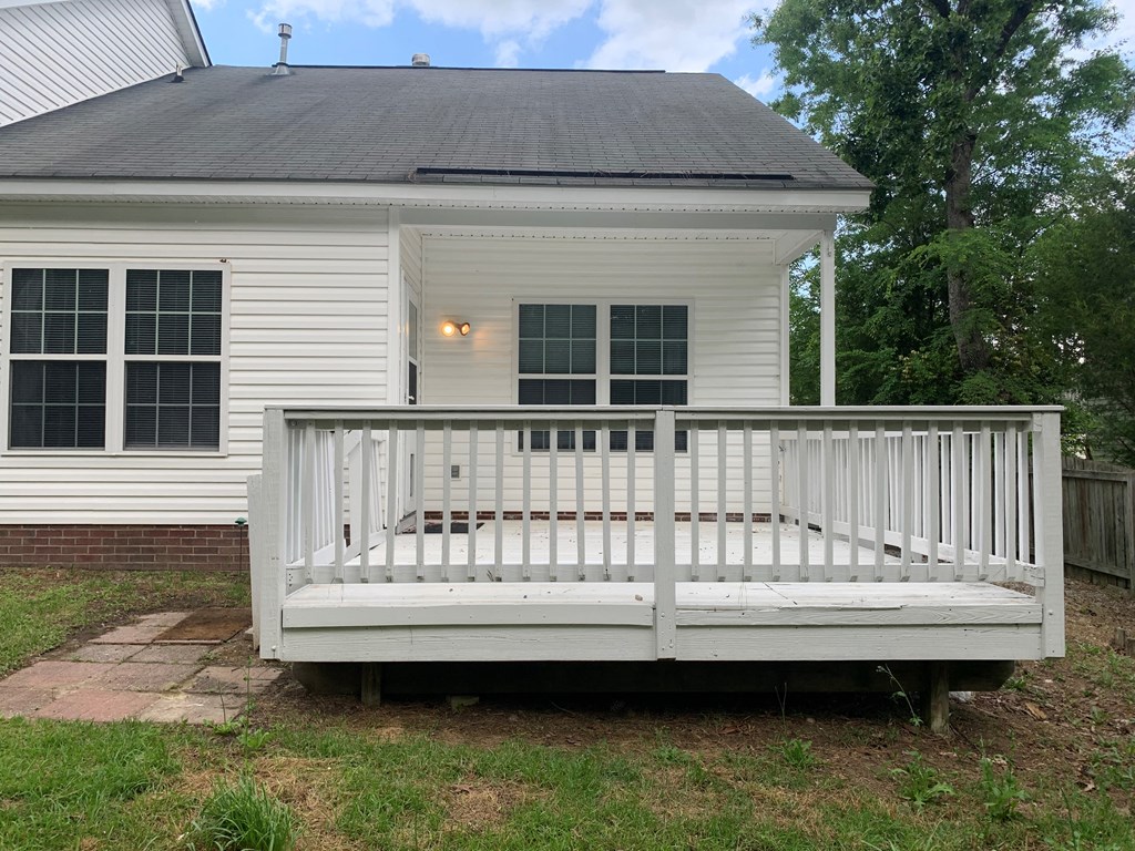 a porch with a white deck in front of a white house