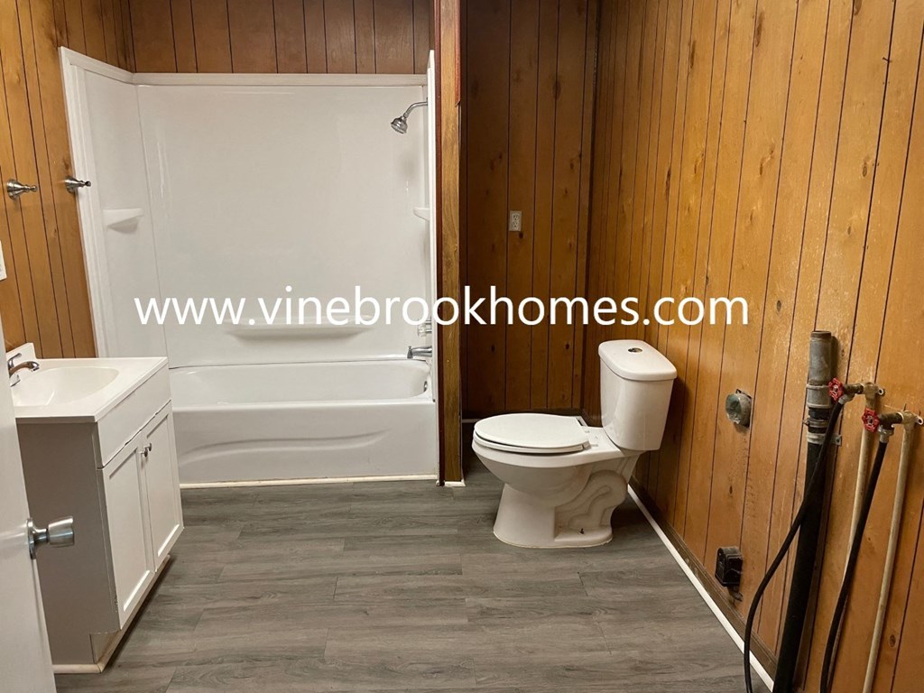 a bathroom with a toilet and a tub and a sink