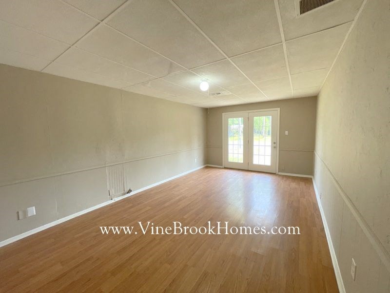 an empty living room with wood floors and white walls