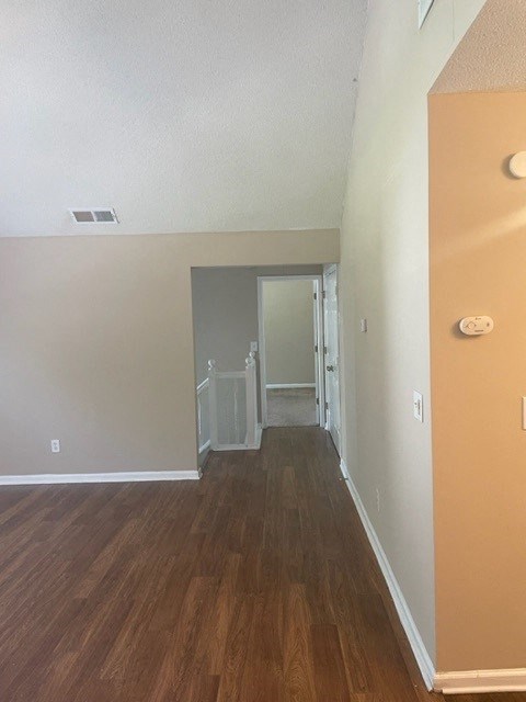 a empty room with a wood floor and a hallway