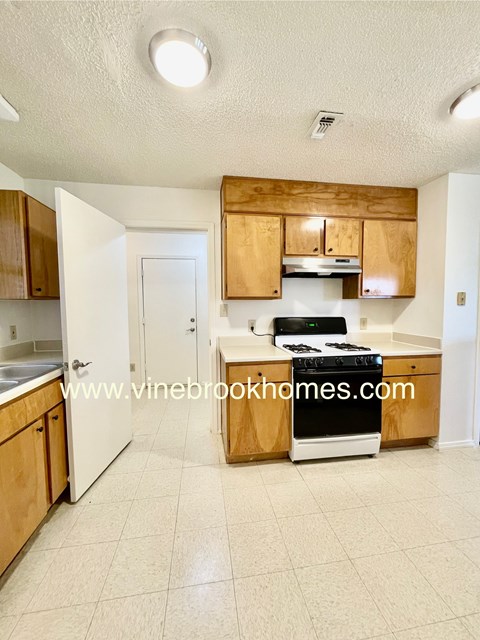 A kitchen with wooden cabinets and a black stove top oven.
