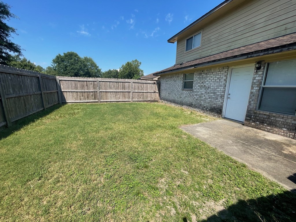 a backyard with a fence and a house