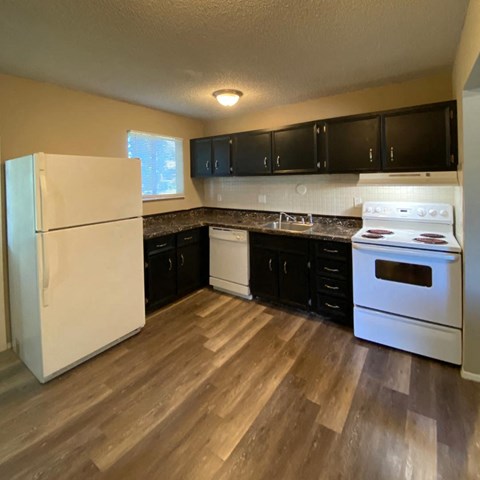 a kitchen with white appliances and black cabinets