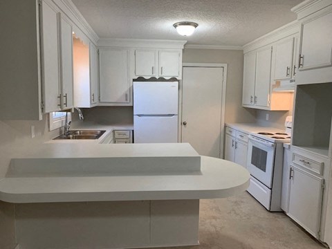 A kitchen with white appliances and cabinets.
