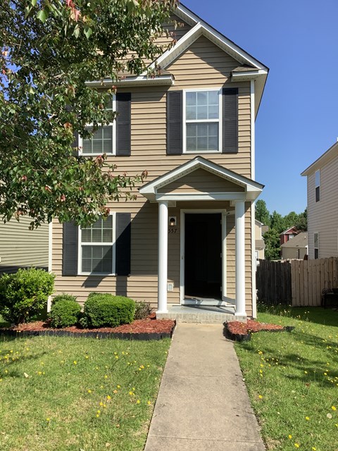 A house with a brown siding and a white door.
