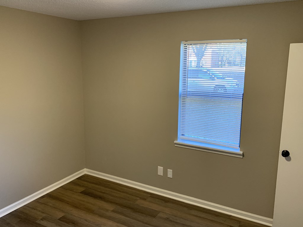 a room with a window and wooden floors
