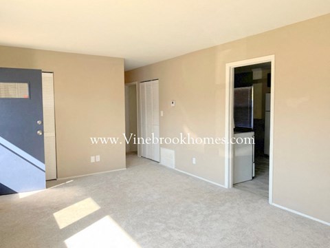 A room with a door on the left and a closet on the right.