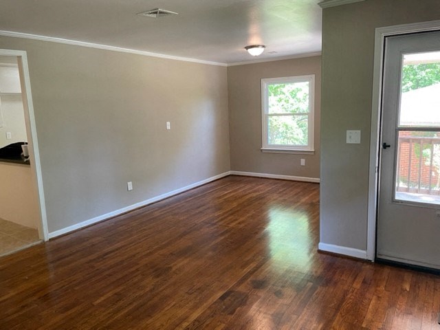 an empty living room with a hard wood floor