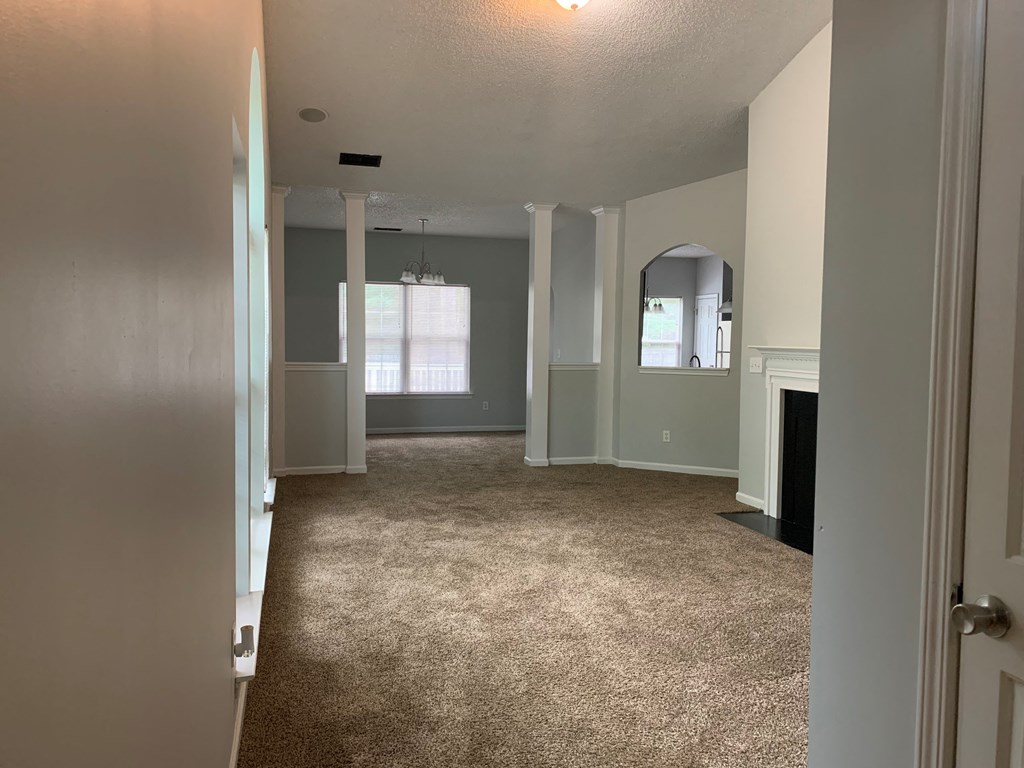 a living room with a carpeted floor and a fireplace