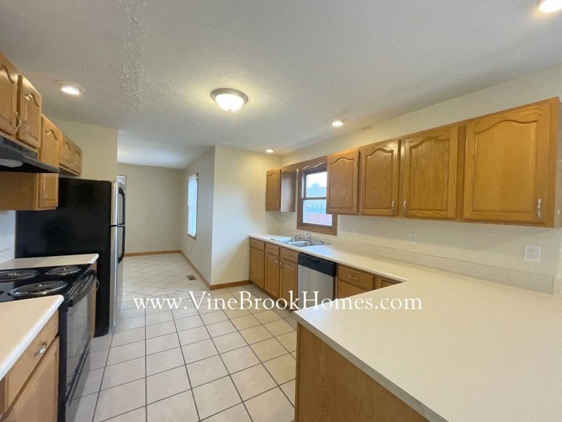 a kitchen with a white counter top and wooden cabinets