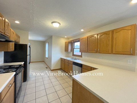 a kitchen with a white counter top and wooden cabinets