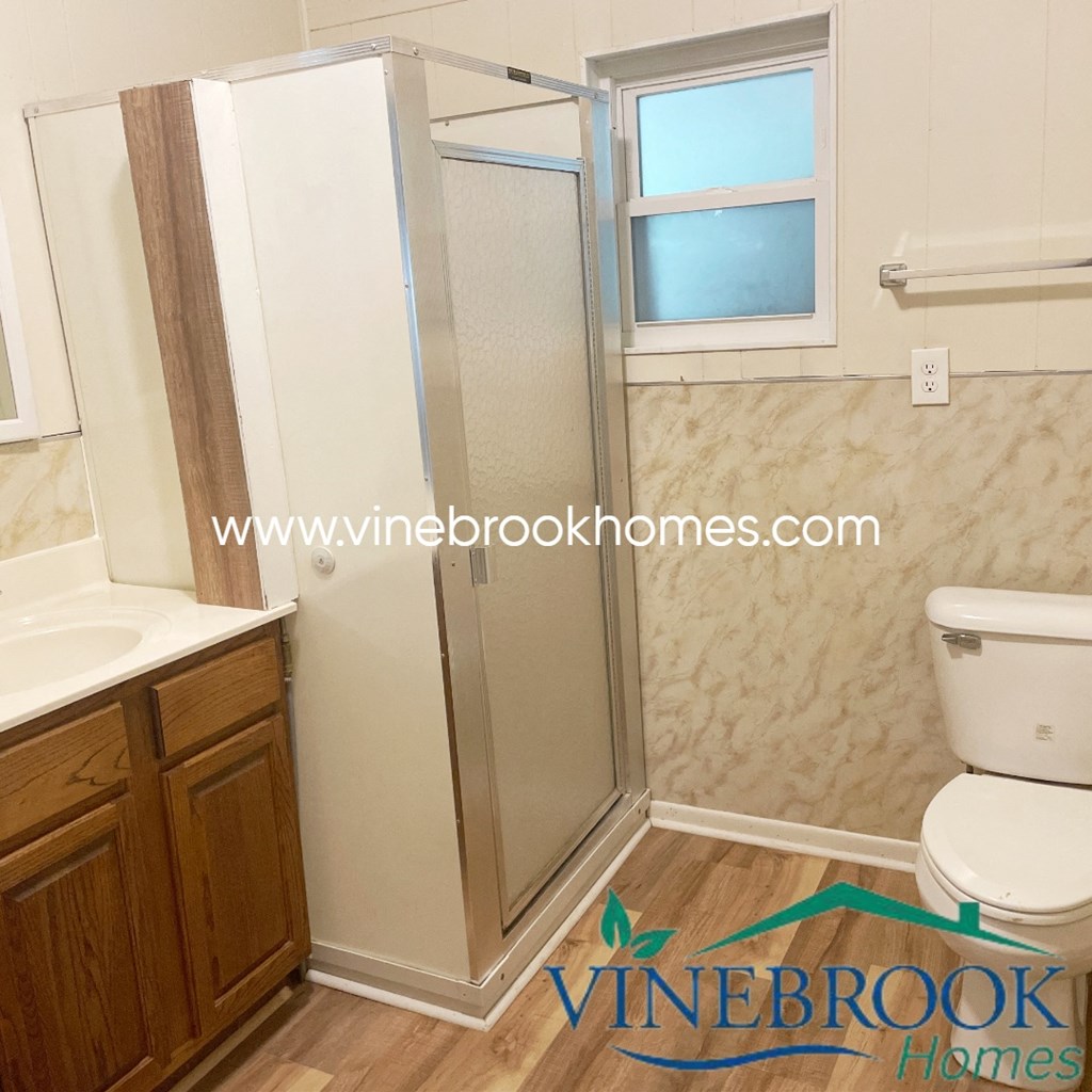 a bathroom with a shower and a sink and a toilet