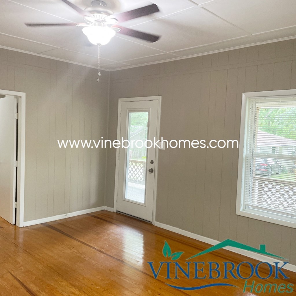 a living room with wood floors and a ceiling fan
