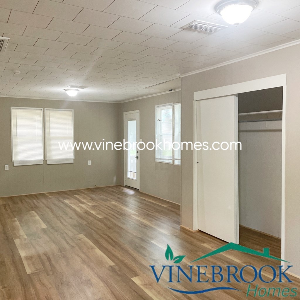 a renovated living room with a hard wood floor and grey walls