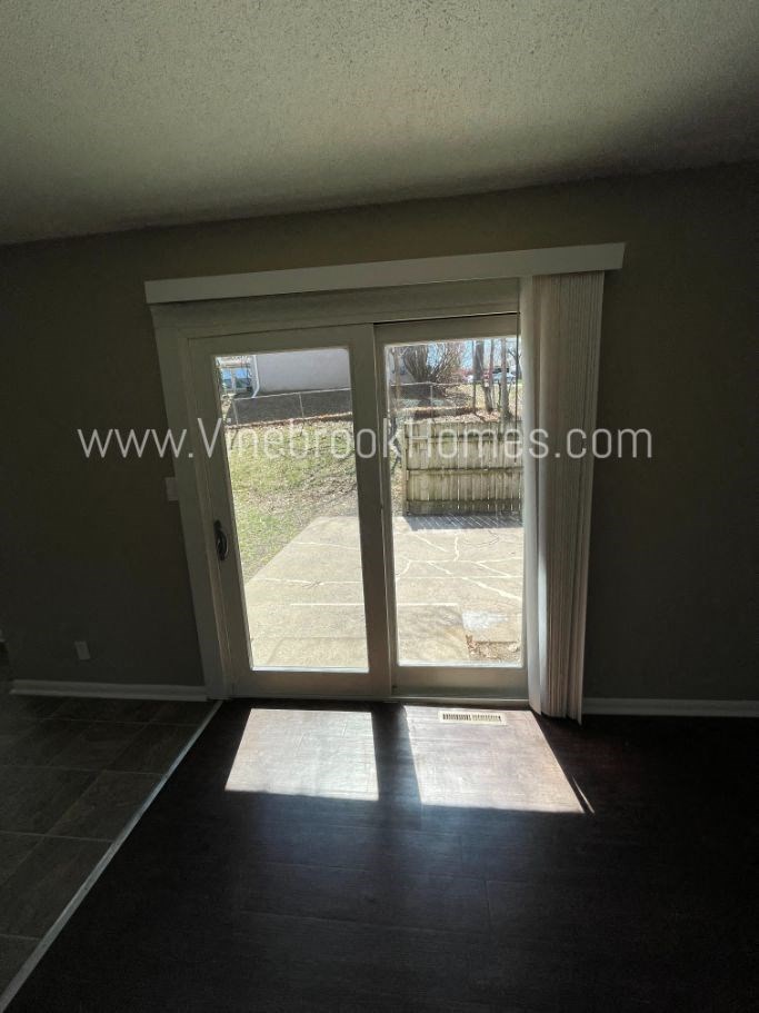 an empty living room with a door to a patio
