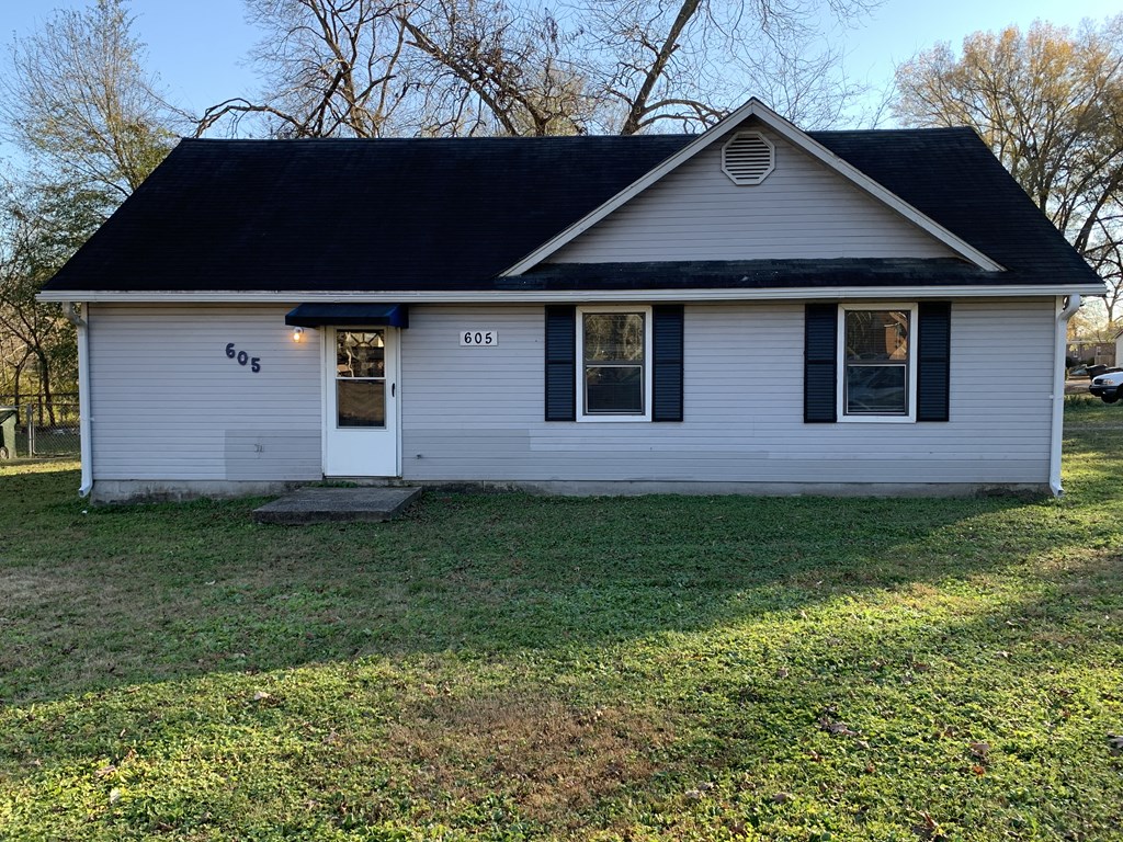 a white house with a black roof on a lawn