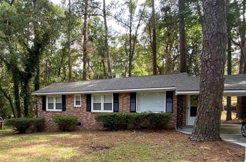 a small brick house in the middle of the woods