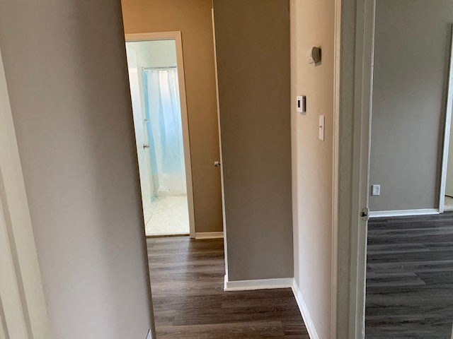 a hallway with a door to a bathroom and a mirror