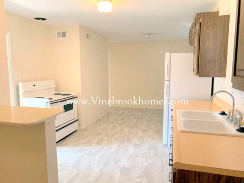A kitchen with a white oven and a white fridge.