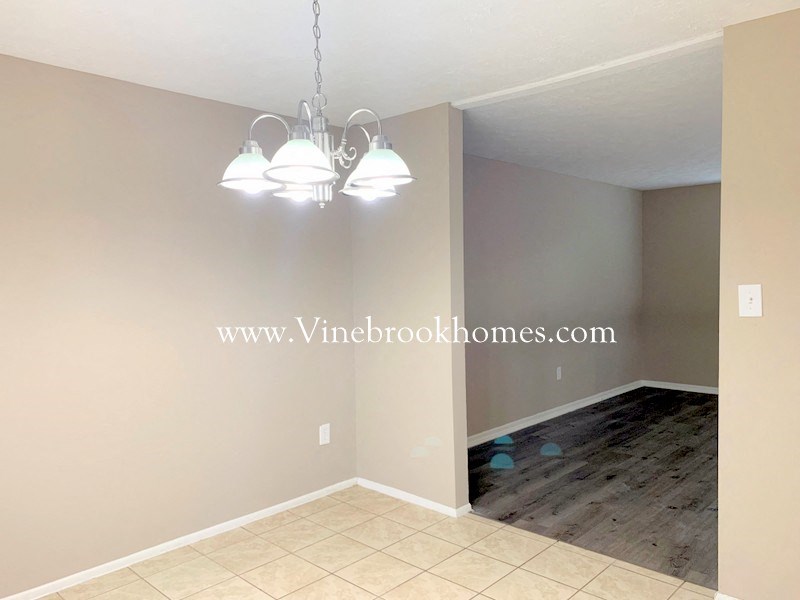 a empty dining room with two lights and a wood floor