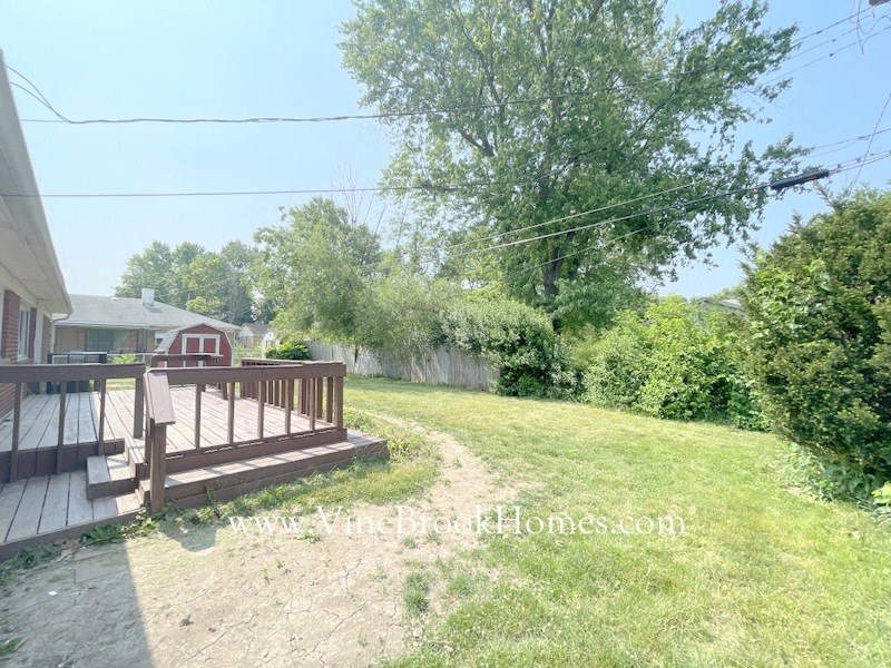 a backyard with a deck and a yard and a house