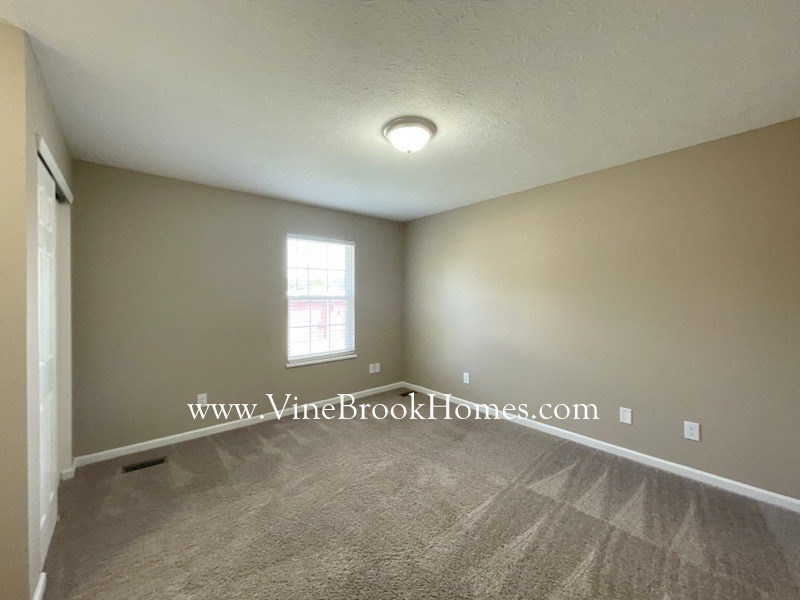 a bedroom with a carpeted floor and a window