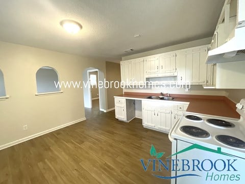 a full view of a kitchen with white cabinets and a stove