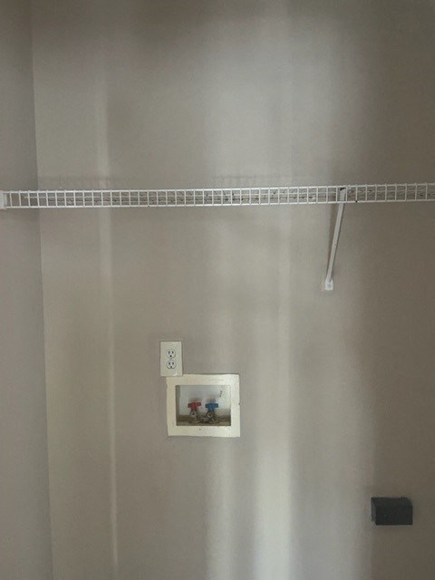 a bathroom with a shower rod and a picture on the wall